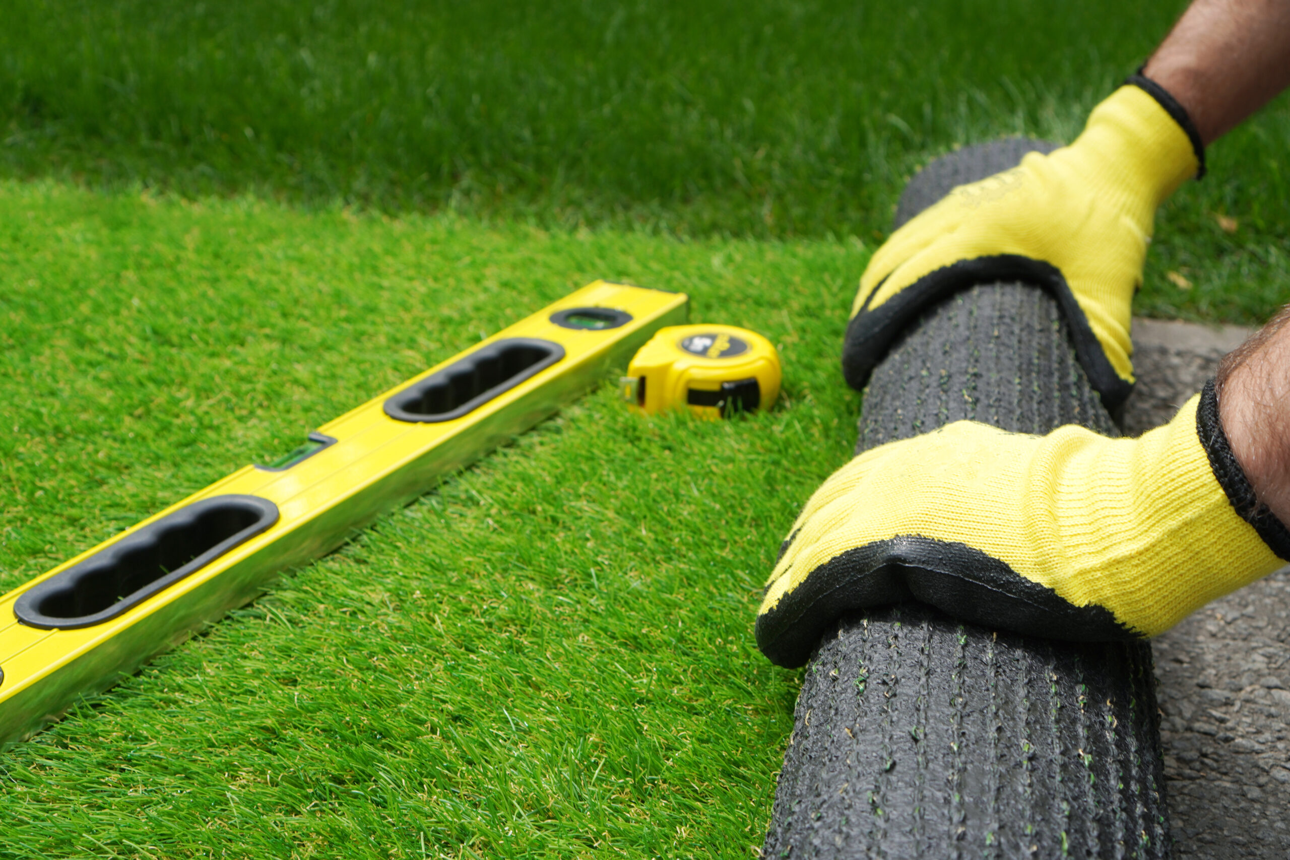 Man’s,Hands,Spread,An,Artificial,Turf,Roll
